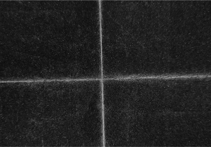 Schwarze Oberfläche mit zweidimensionalen weißen Kreidelinien, die sich in der Mitte kreuzen.